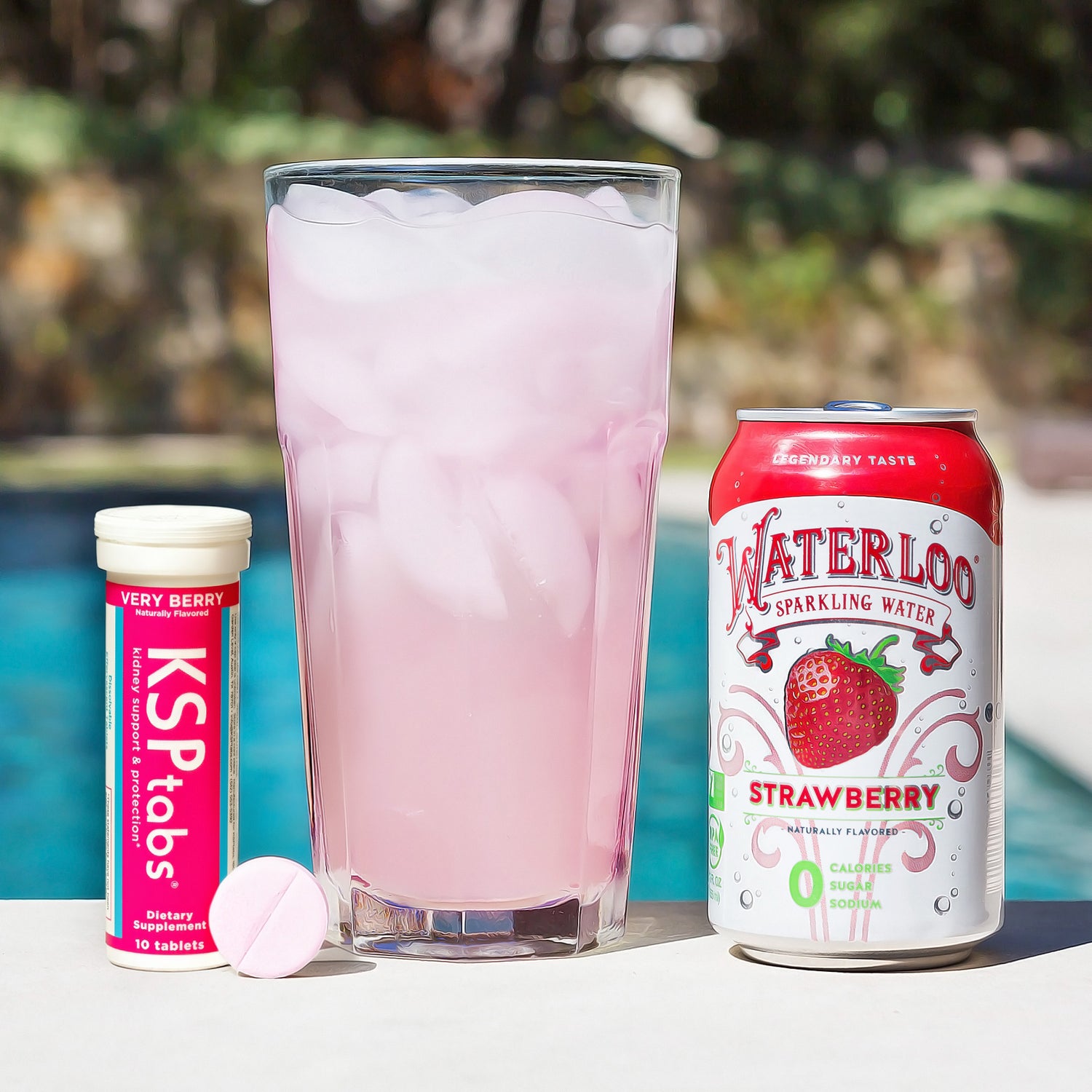 Berry KSPtabs next to a glass and Waterloo Strawberry sparkling water next to a pool.